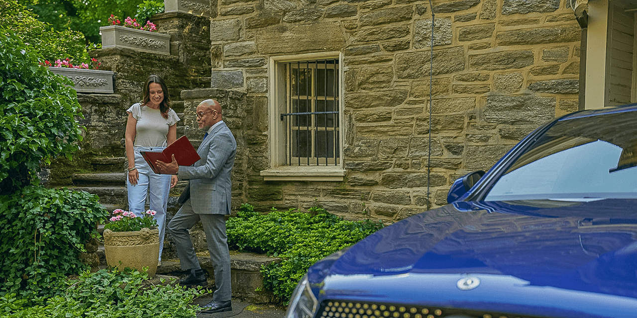 Two people talking near a classic stone building