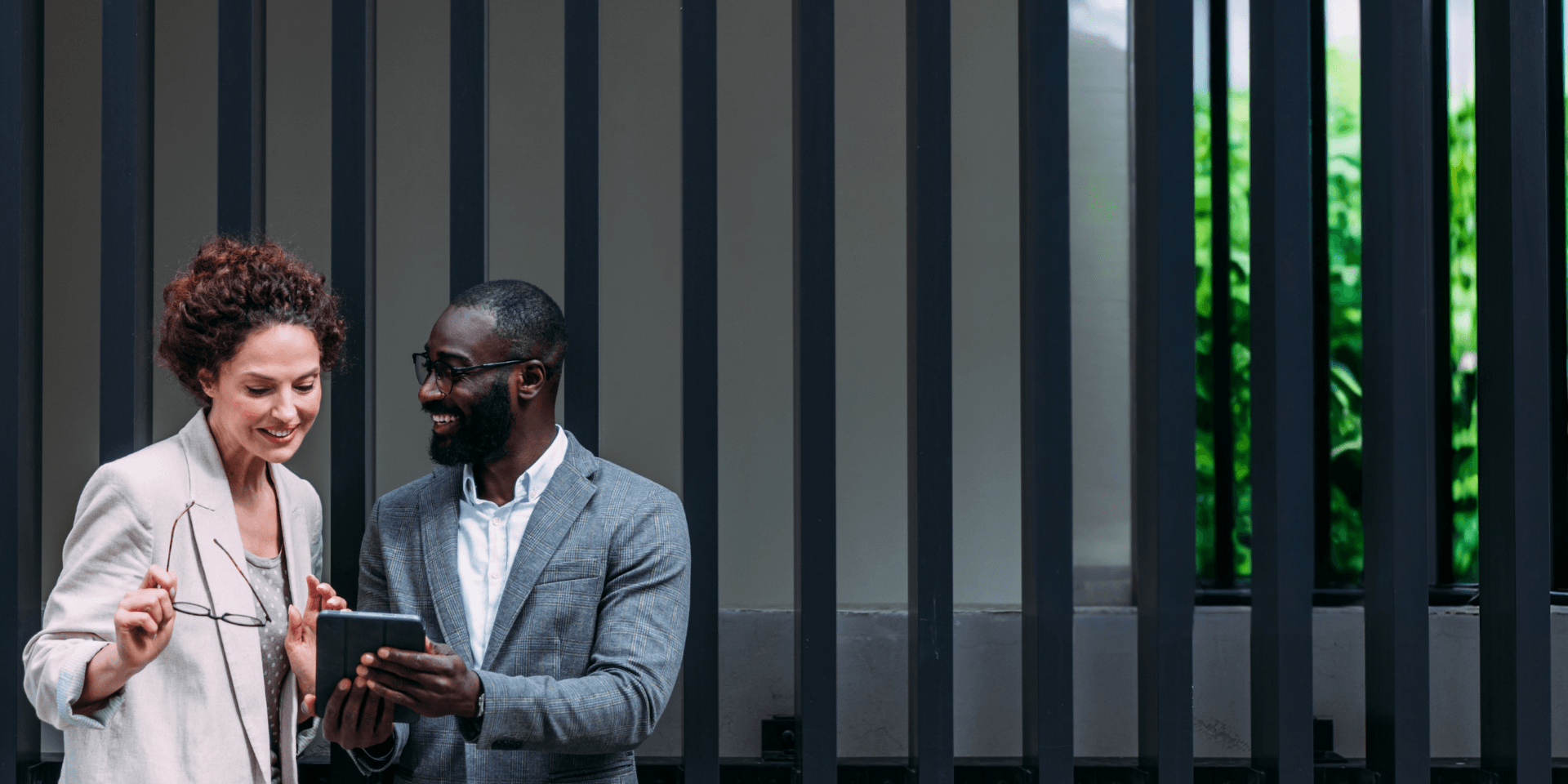 Professional man and woman looking at a tablet together in an office setting